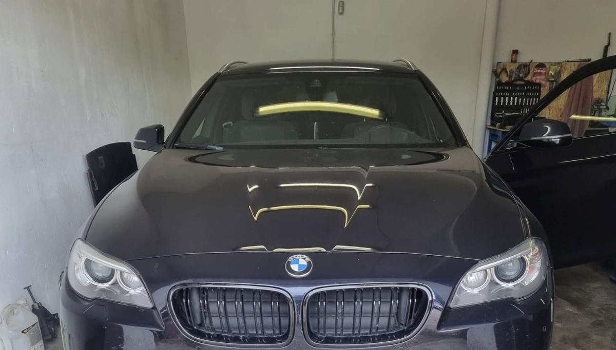 BMW universalas ant apžiūros duobės dirbtuvėse